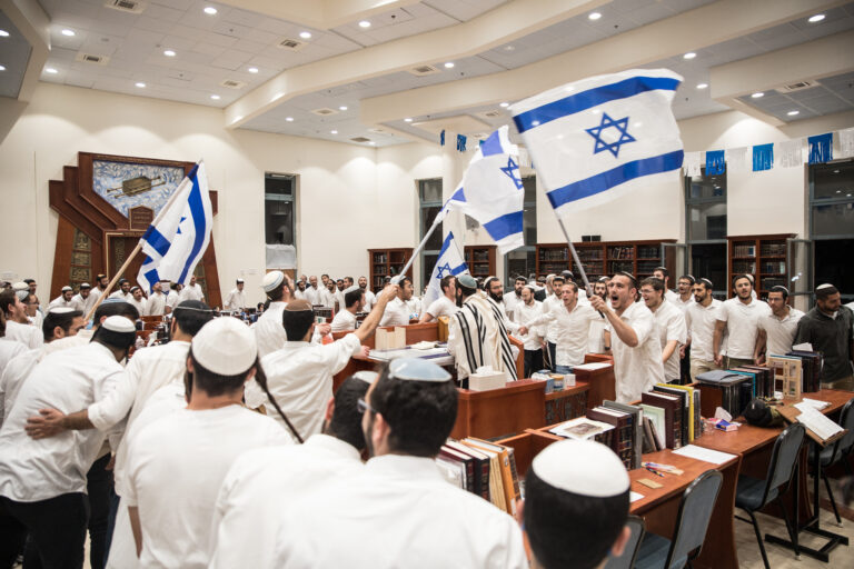 ריקודים עם דגלי ישראל בבית המדרש